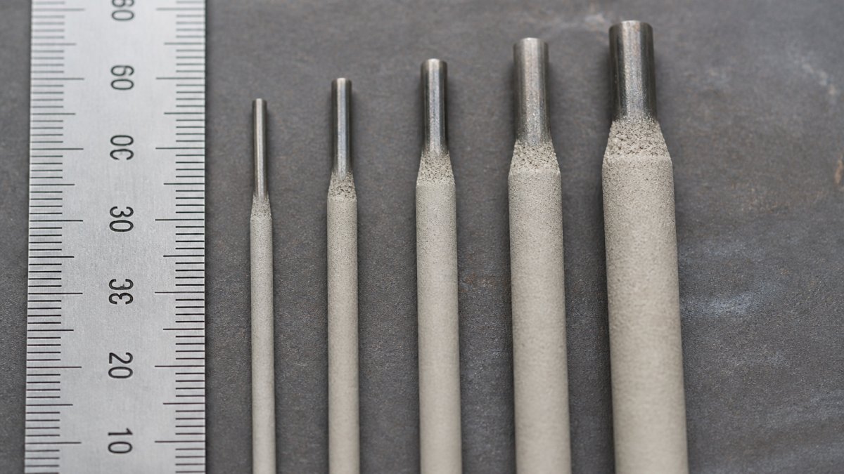 best welding electrodes for small fabrication shops content 1 1791705810 Close-up of five welding electrodes arranged in order of increasing diameter, showing 1.6mm through 4.0mm rods positioned next to a metal ruler marked in millimetres, with clear visibility of the coating differences between rod sizes